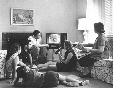 Figure 28.16 An American family relaxes in front of their television set in 1958. Many gathered not only to watch the programming but also to eat dinner. The marketing of small folding tray tables and frozen “TV dinners” encouraged such behavior.