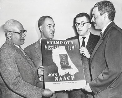 Figure 28.19 In 1956, NAACP leaders (from left to right) Henry L. Moon, Roy Wilkins, Herbert Hill, and Thurgood Marshall present a new poster in the campaign against southern white racism. Marshall successfully argued the landmark case Brown v. Board of Education (1954) before the U.S. Supreme Court and later became the court’s first African American justice.